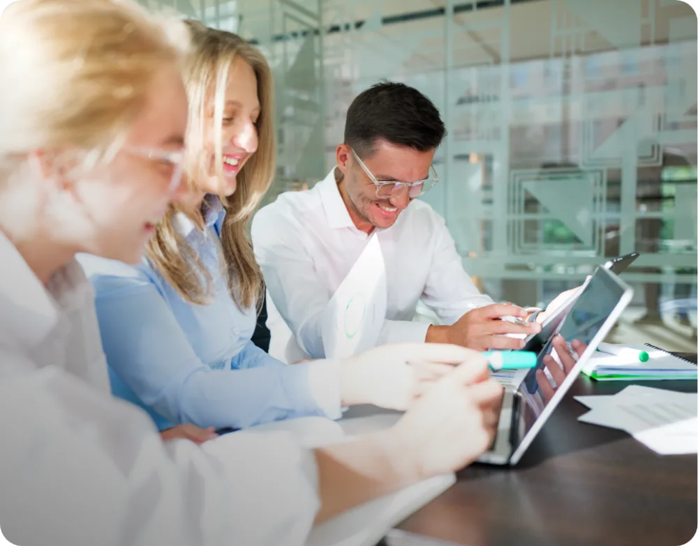 Field application engineers reviewing a project on a tablet at a meeting table