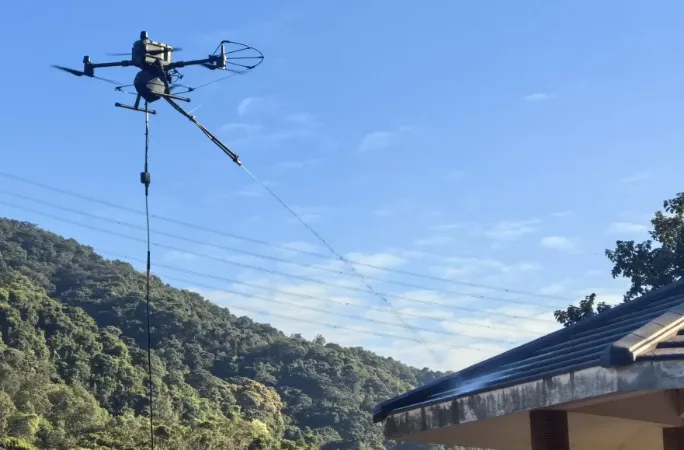 Tethered drone working on a mountain site under a blue sky