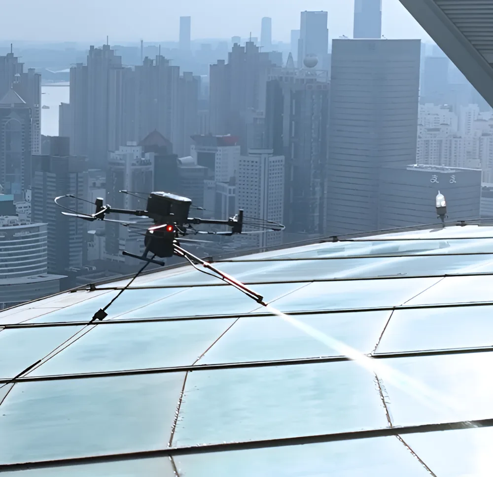 Drone-mounted cleaning robot spraying a sloped glass roof above a city skyline
