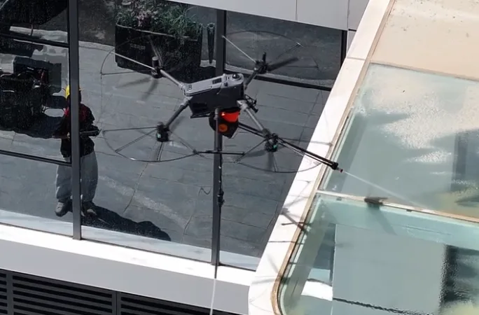 Drone cleaning the glass balustrade of a building from above